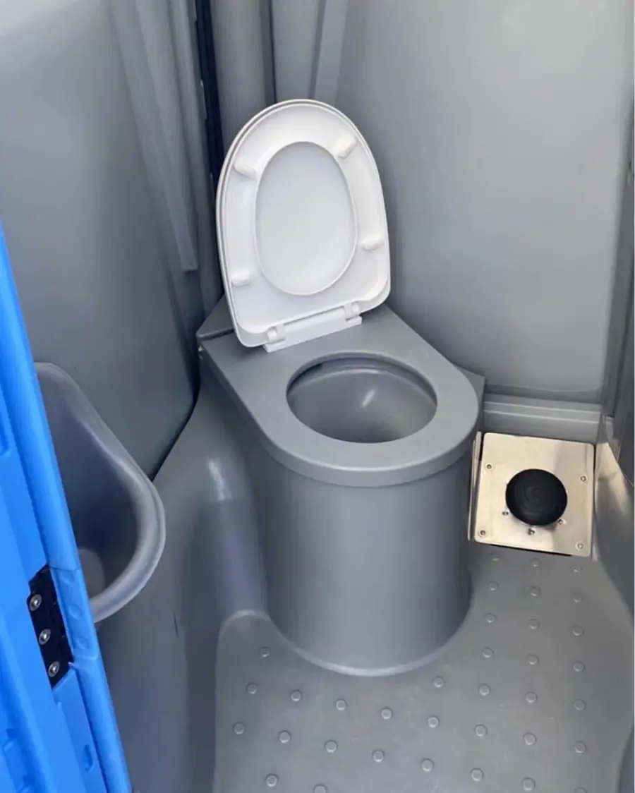Inside a flushing portable toilet with a toilet bowl and foot pump